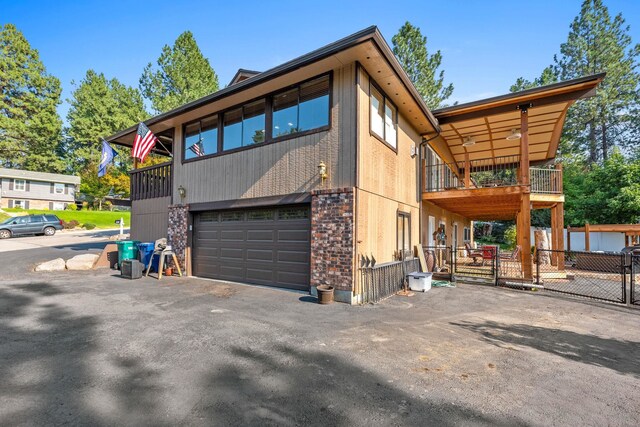 view of side of home featuring a garage and a balcony