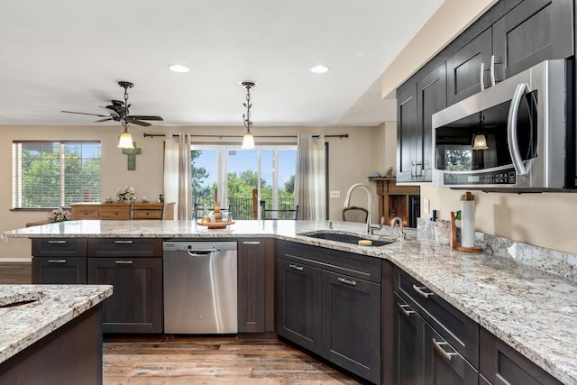 kitchen featuring appliances with stainless steel finishes, light wood-type flooring, plenty of natural light, and sink