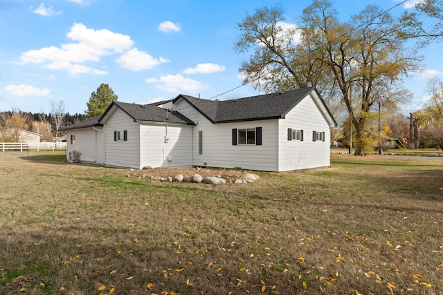 view of side of home with a yard