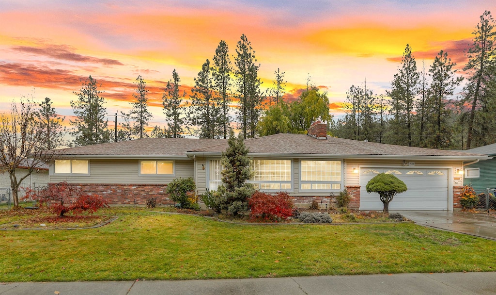 ranch-style home featuring a yard and a garage