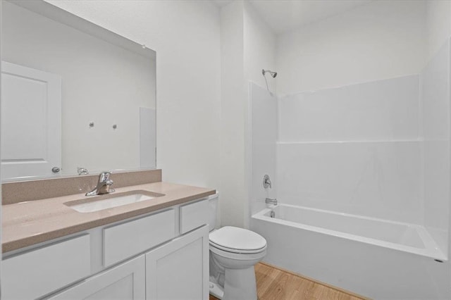 full bathroom with shower / bath combination, vanity, wood-type flooring, and toilet