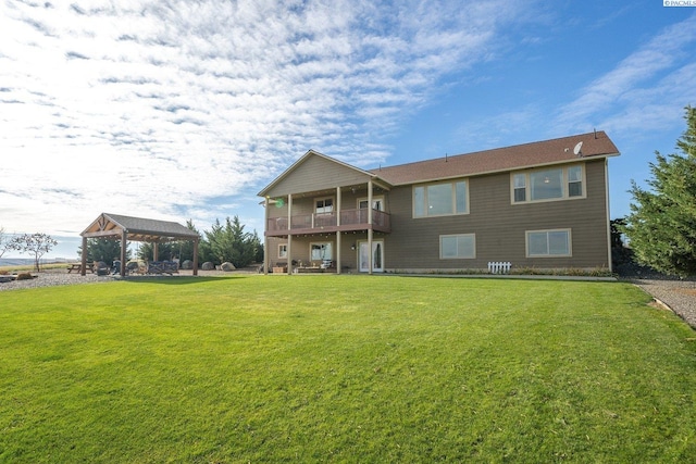 rear view of house featuring a gazebo, a yard, and a balcony