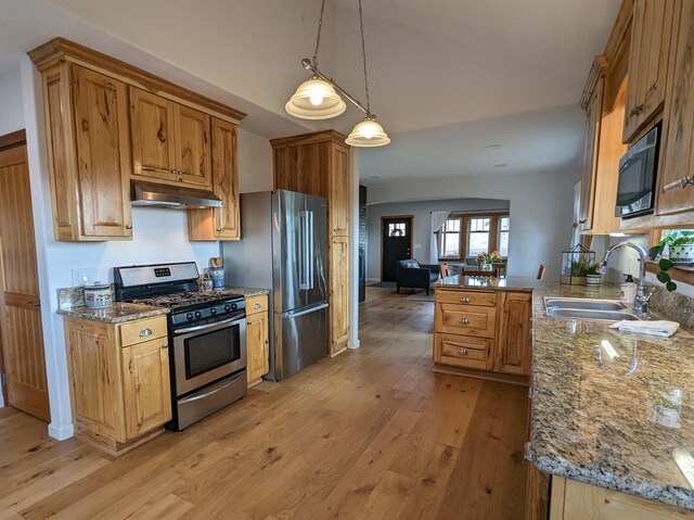 kitchen featuring pendant lighting, sink, light wood-type flooring, appliances with stainless steel finishes, and kitchen peninsula