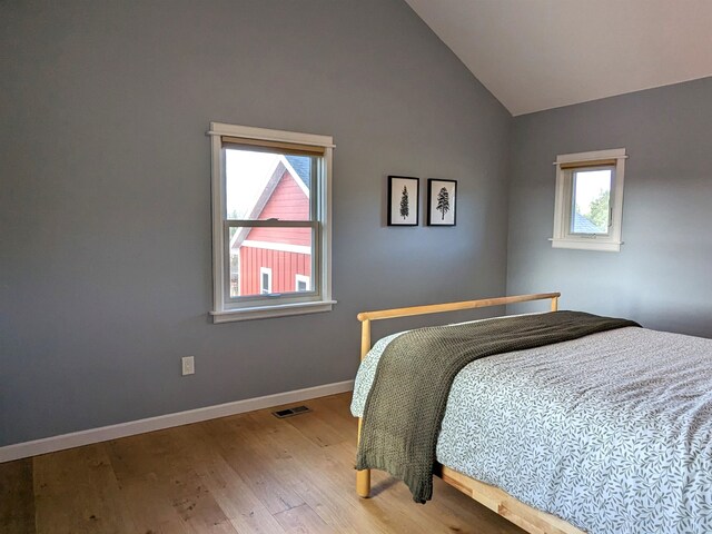 bedroom featuring hardwood / wood-style floors and lofted ceiling