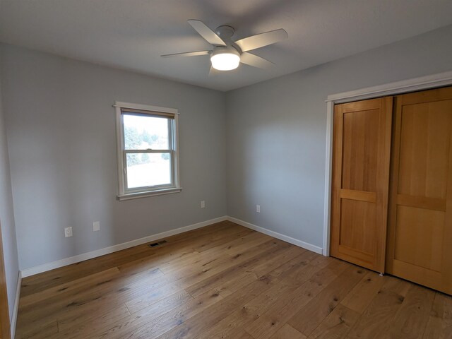 unfurnished bedroom with light wood-type flooring, a closet, and ceiling fan