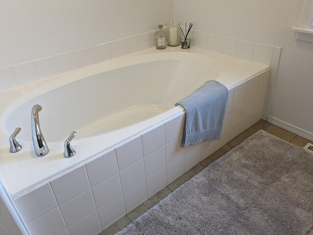 bathroom with tile patterned floors and tiled tub