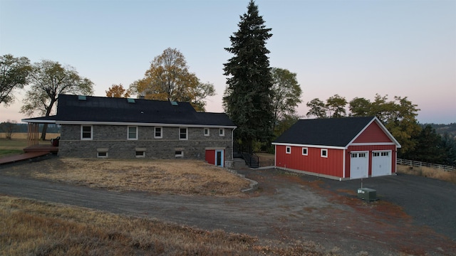 view of front of home with a garage, cooling unit, and an outdoor structure