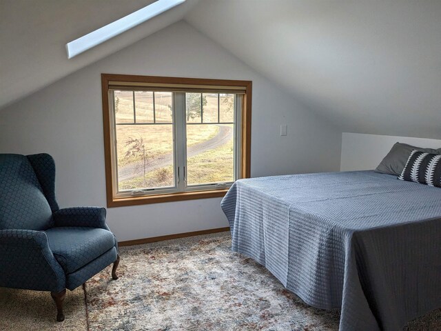 carpeted bedroom with vaulted ceiling with skylight