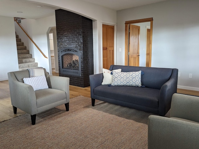 living room with a fireplace and wood-type flooring