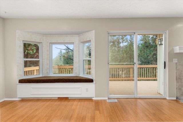 interior space with light wood-type flooring and a textured ceiling