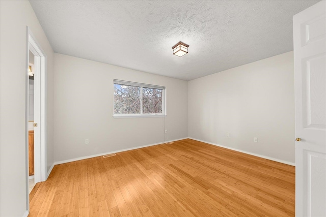 unfurnished room featuring a textured ceiling and hardwood / wood-style flooring