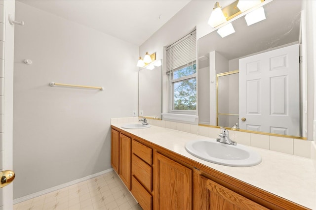 bathroom featuring a skylight, vanity, and a shower with shower door