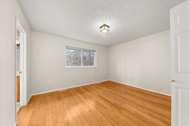 4815 S Kip Ln, Spokane, WA 99224 - empty room featuring light wood-style floors, baseboards, and a textured ceiling