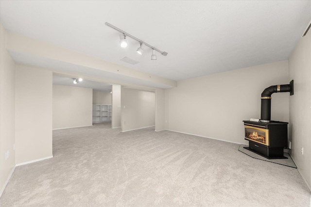 4815 S Kip Ln, Spokane, WA 99224 - finished below grade area with a wood stove, carpet floors, baseboards, and rail lighting