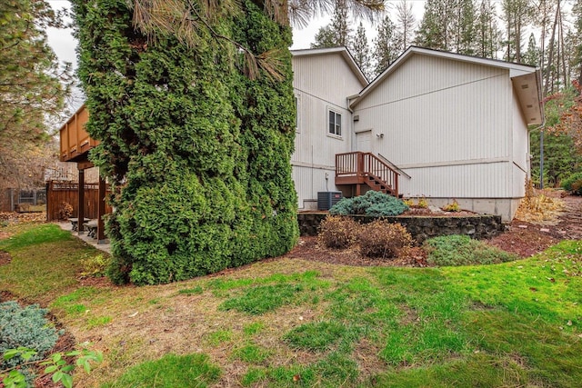 back of property with a yard and central AC