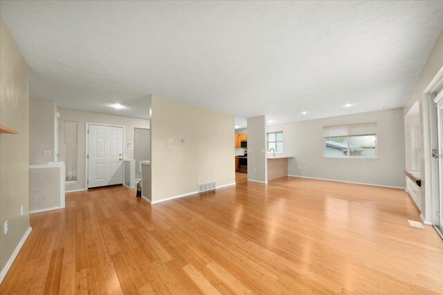 4815 S Kip Ln, Spokane, WA 99224 - unfurnished living room featuring light wood-style flooring, baseboards, a sink, and recessed lighting