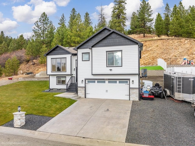 raised ranch featuring a front yard and a garage