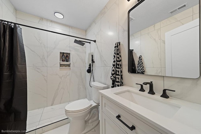 bathroom featuring vanity, toilet, tile walls, and walk in shower