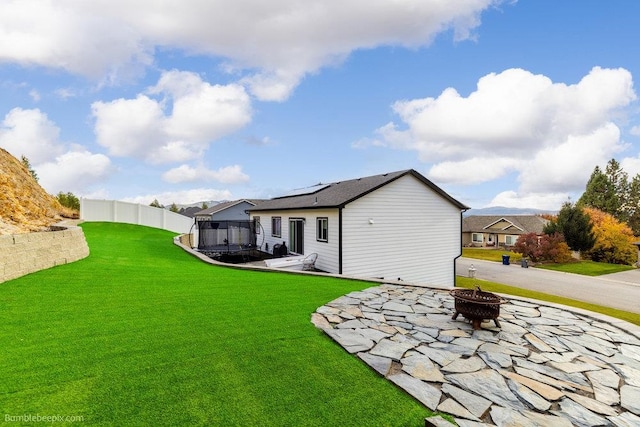 rear view of house with a yard and a fire pit