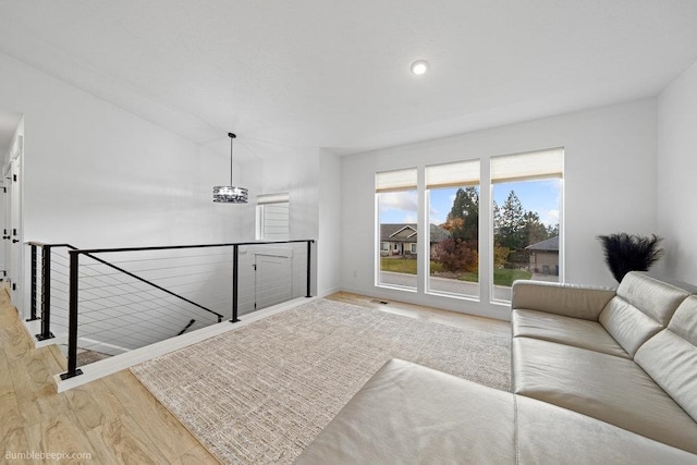 living room featuring a notable chandelier and light wood-type flooring