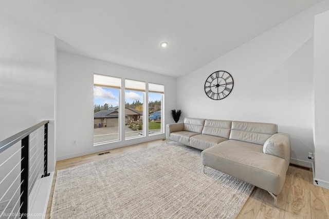 living room featuring light hardwood / wood-style floors and lofted ceiling