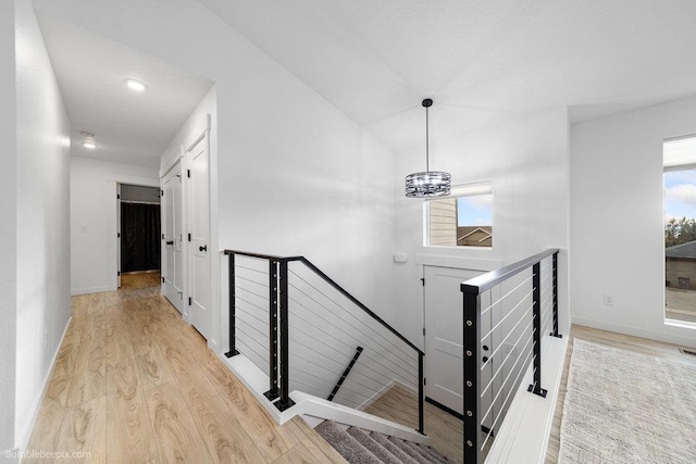 staircase featuring wood-type flooring and a chandelier