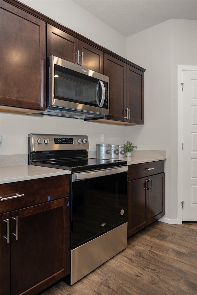 kitchen featuring dark brown cabinets, dark hardwood / wood-style flooring, and stainless steel appliances