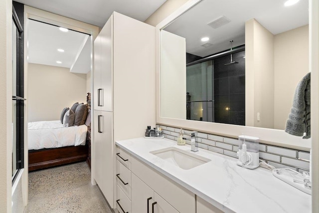 bathroom featuring backsplash, vanity, and a shower with shower door