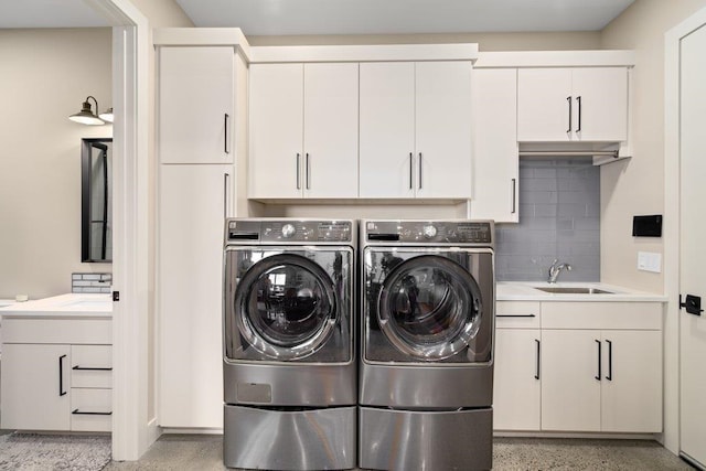 laundry area with separate washer and dryer, sink, and cabinets