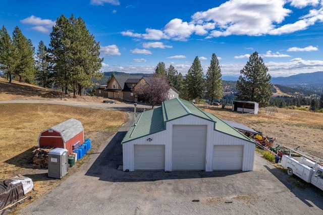 exterior space featuring a mountain view, an outbuilding, and a garage