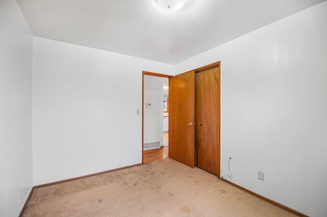 spare room featuring light colored carpet