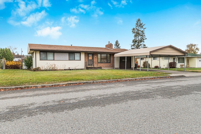 ranch-style house featuring a front lawn and a carport