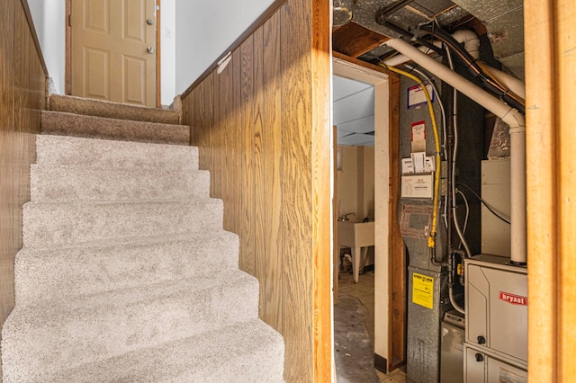 stairs featuring wooden walls and concrete floors