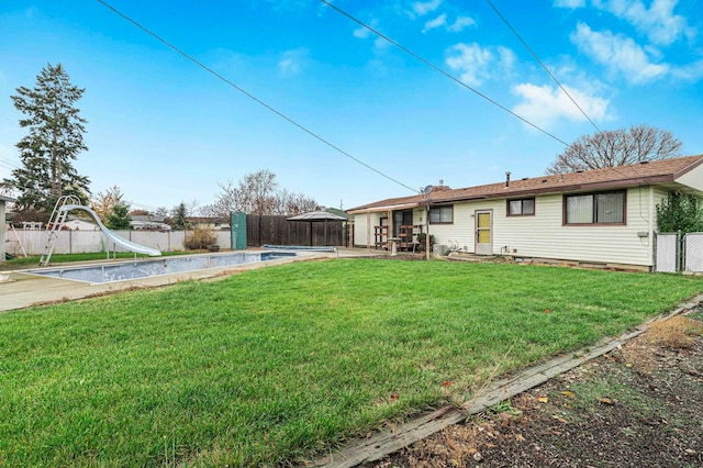 back of house with a yard and a patio