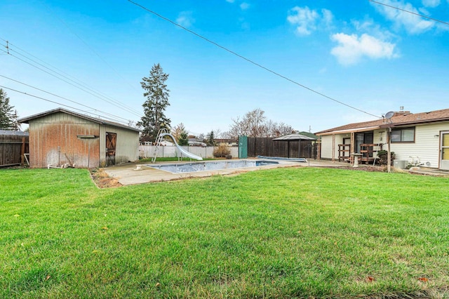 view of yard with an outbuilding, a fenced in pool, and a patio area