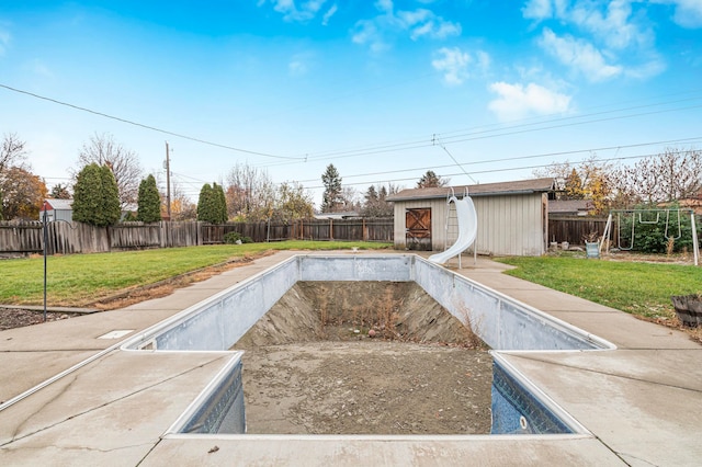 view of pool with a lawn and a shed