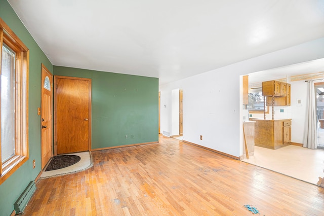 unfurnished living room with light wood-type flooring and a baseboard radiator