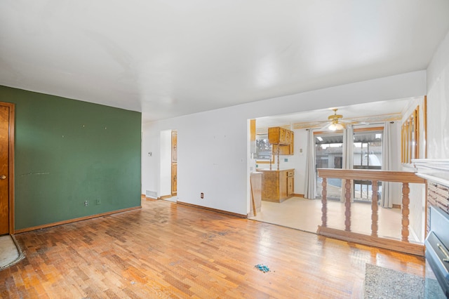 unfurnished living room with light hardwood / wood-style flooring and ceiling fan