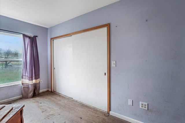 unfurnished bedroom featuring a closet and multiple windows