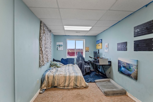 bedroom featuring carpet floors and a drop ceiling