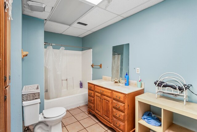 full bathroom with a drop ceiling, shower / bath combo, tile patterned floors, toilet, and vanity