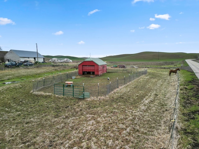 view of play area with a mountain view, a rural view, and an outbuilding