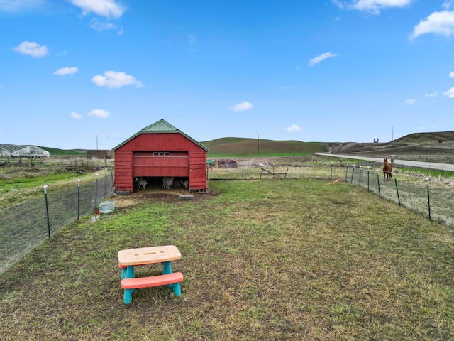 view of yard with a mountain view, a rural view, and an outbuilding