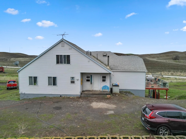 back of property with a deck with mountain view