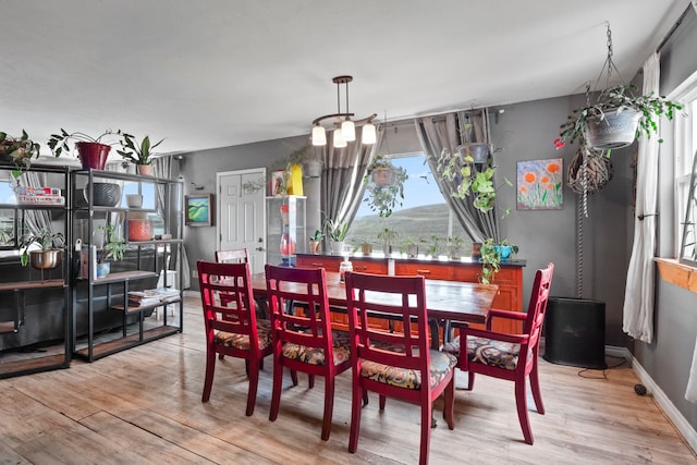 dining area with an inviting chandelier and light wood-type flooring