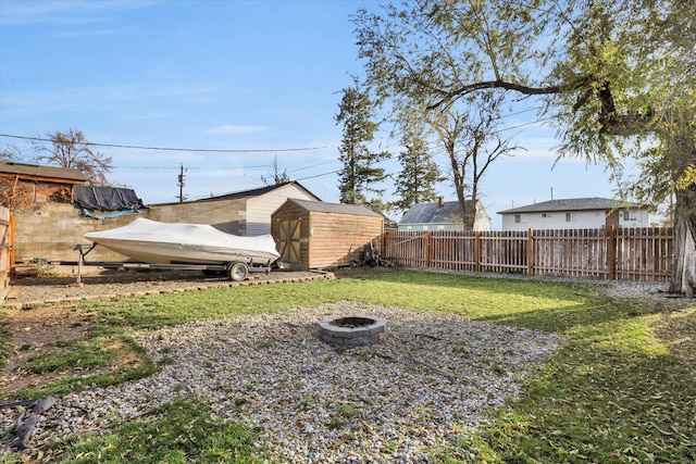 view of yard with an outdoor fire pit and a storage shed