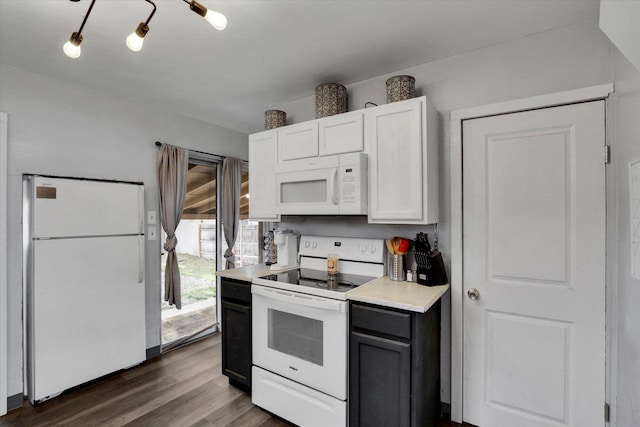 kitchen featuring dark hardwood / wood-style flooring, white cabinets, and white appliances