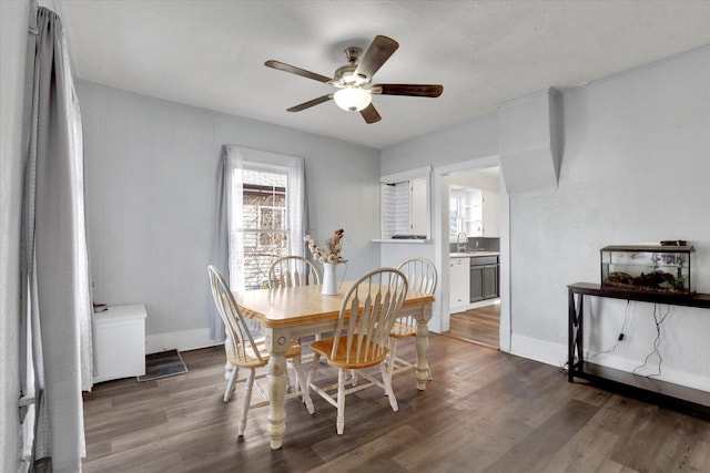 dining area featuring ceiling fan, sink, and dark hardwood / wood-style floors