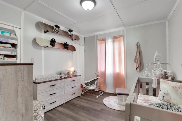 bedroom with dark hardwood / wood-style flooring and ornamental molding