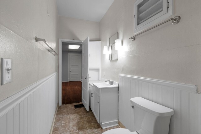 bathroom featuring toilet, vanity, and walk in shower